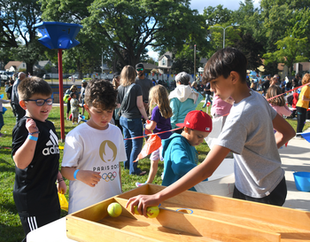 Students enjoying Septemberfair with festival games and crowd of people in the background