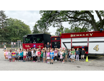 Group of children standing in front of a Berkley fire truck.